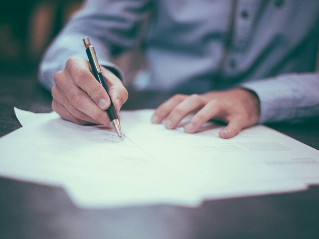 Person reviewing and writing on paper documents