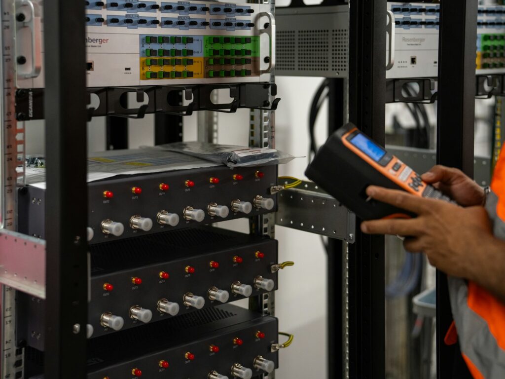 Technician inspecting server racks with a diagnostic tool